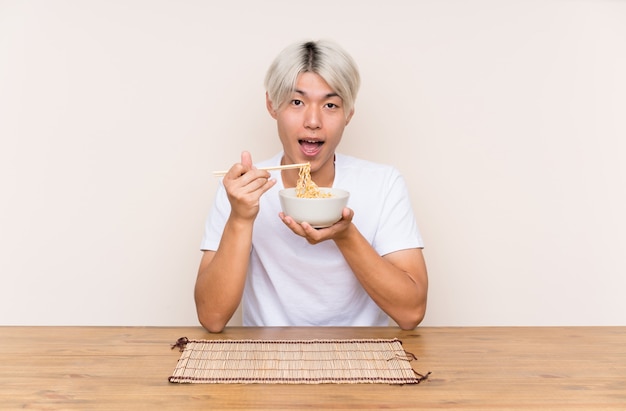 Jeune homme asiatique avec ramen dans une table