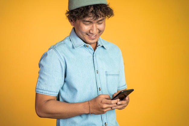 Jeune homme asiatique regardant l'écran d'un téléphone portable