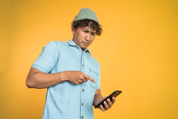 Jeune homme asiatique regardant l'écran d'un téléphone portable