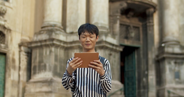 Jeune homme asiatique regardant une tablette