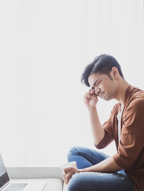 Jeune homme asiatique se frottant les yeux