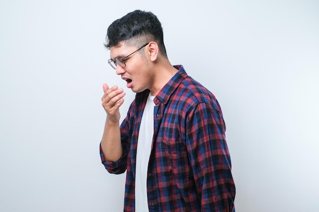 Jeune homme asiatique sentant quelque chose de puant et dégoûtant odeur intolérable retenant son souffle avec les doigts sur le nez Mauvaise odeur