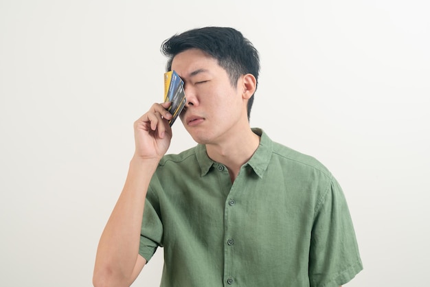 Jeune homme asiatique stressant avec la facturation par carte de crédit