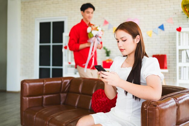 Photo un jeune homme asiatique a surpris sa petite amie en lui donnant un bouquet de roses pour son anniversaire.