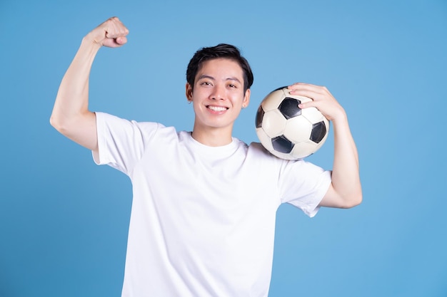 Jeune homme asiatique tenant le ballon sur fond