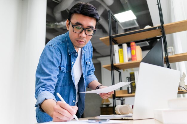 Jeune homme asiatique travaillant au bureau