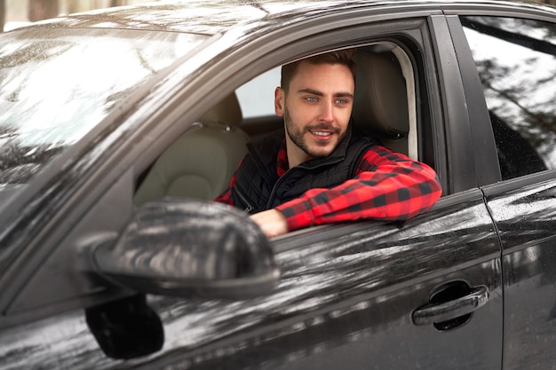 Jeune homme assis au volant de sa voiture