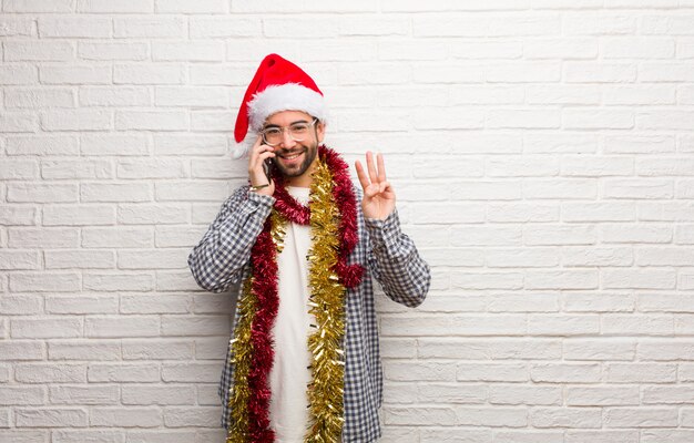 Jeune homme assis avec des cadeaux pour célébrer Noël, numéro trois