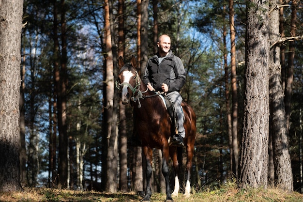 Jeune homme assis sur un cheval à l'extérieur