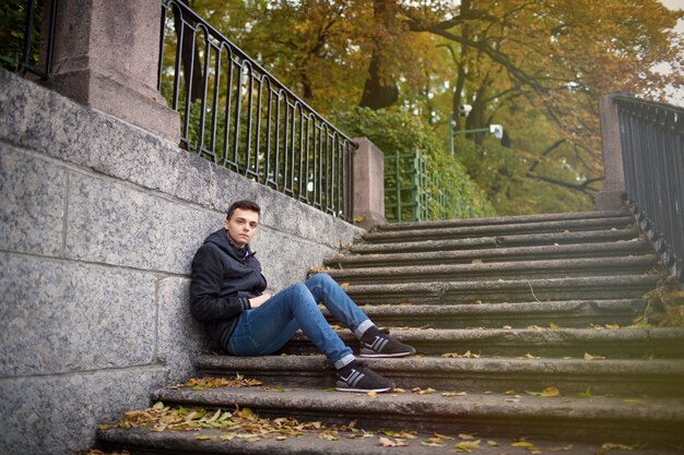 Un jeune homme assis dans l&#39;escalier.