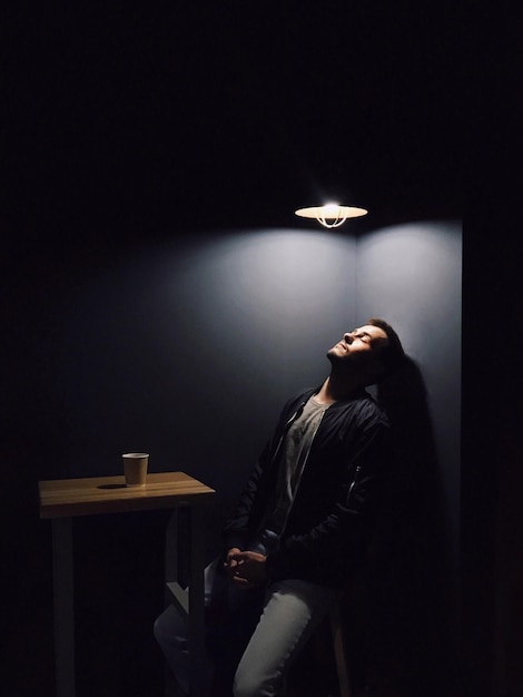 Un jeune homme assis à l'intérieur.