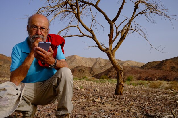 Photo un jeune homme assis sur une montagne