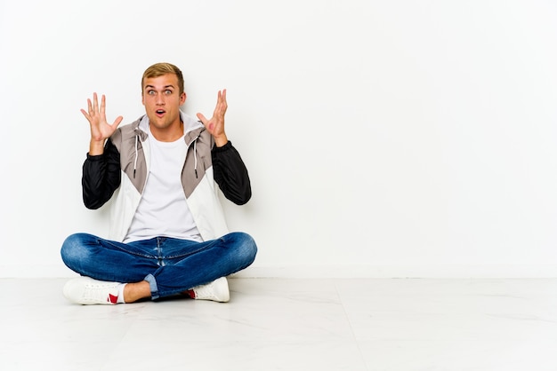 Jeune homme assis sur le sol ayant une idée, concept d'inspiration