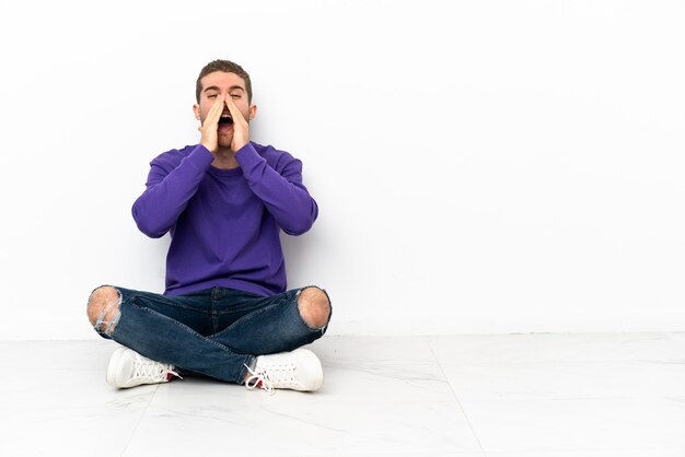 Jeune homme assis sur le sol criant et annonçant quelque chose