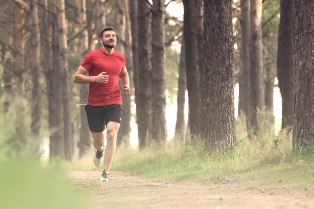 Jeune homme athlétique faisant du jogging dans le parc