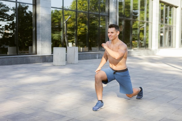 Jeune homme athlétique faisant l'échauffement avant l'entraînement en plein air. Mode de vie sain. Concept de remise en forme