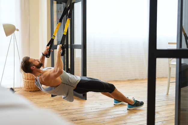 Jeune homme athlétique faisant de l'exercice avec une bande élastique de remise en forme