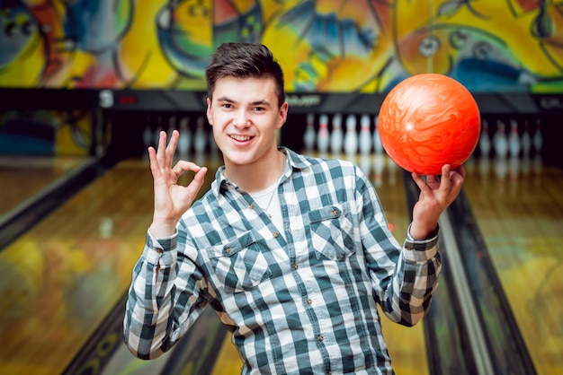 Jeune homme au bowling avec le ballon.