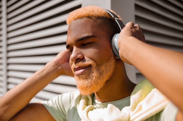 Un jeune homme au casque écoutant de la musique et ayant l'air apprécié