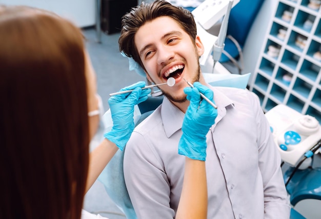 Jeune homme au fauteuil du dentiste lors d'une intervention dentaire Aperçu de la prévention des caries dentaires