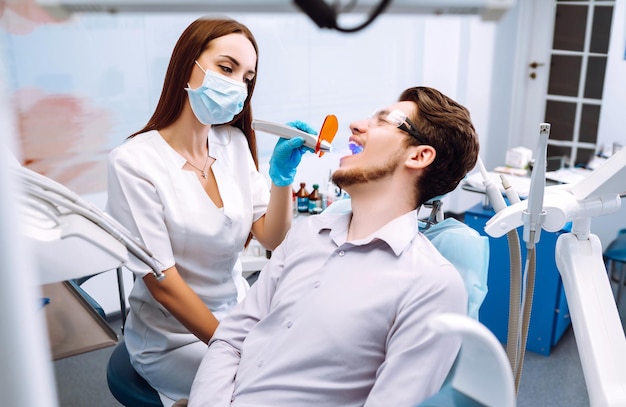 Jeune homme au fauteuil du dentiste lors d'une intervention dentaire Aperçu de la prévention des caries dentaires