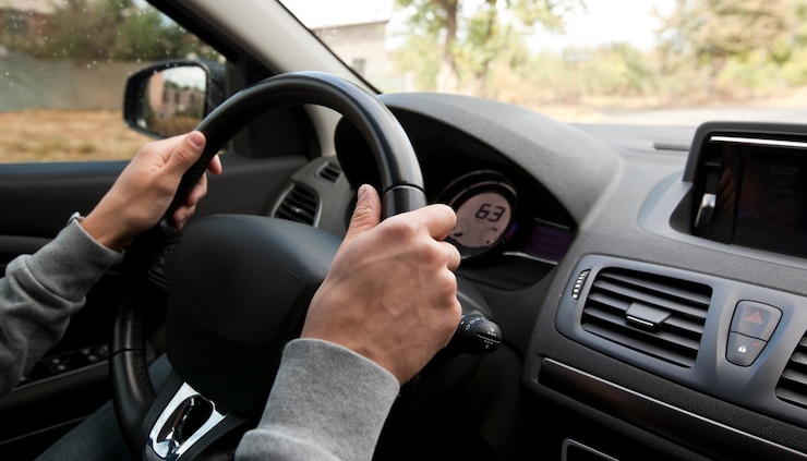 Photo le jeune homme au volant de la voiture moderne sur route asphaltée