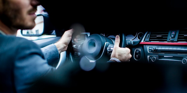 Jeune homme au volant de la voiture moderne