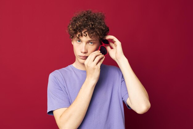 Jeune homme aux cheveux bouclés lunettes de soleil de mode de style d'été fond isolé