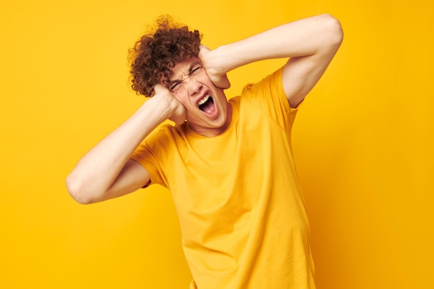 Jeune homme aux cheveux bouclés studio de style jeunesse vêtements décontractés fond isolé inchangé