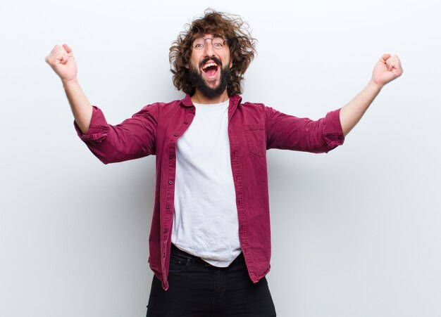 Jeune homme aux cheveux fous en mouvement danser et célébrer