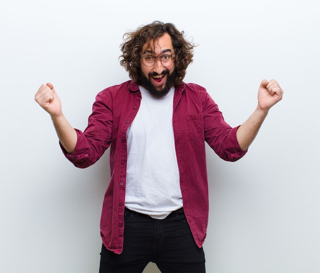 Jeune homme aux cheveux fous en mouvement danser et célébrer