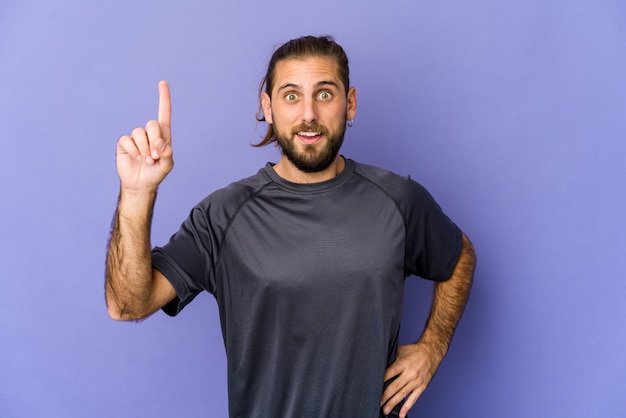 Un jeune homme aux cheveux longs a l'air de douter entre deux options.