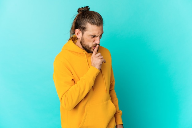 Jeune homme aux cheveux longs gardant un secret ou demandant le silence