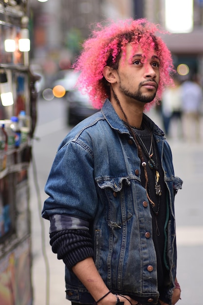 Photo un jeune homme aux cheveux teints se tient dans la rue.