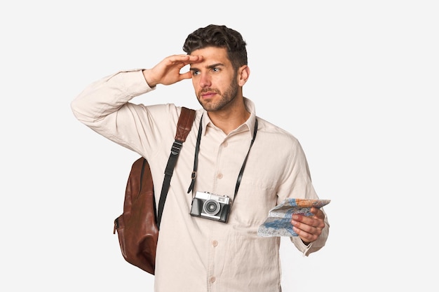 Jeune homme aventureux avec carte d'appareil photo vintage et sac à dos