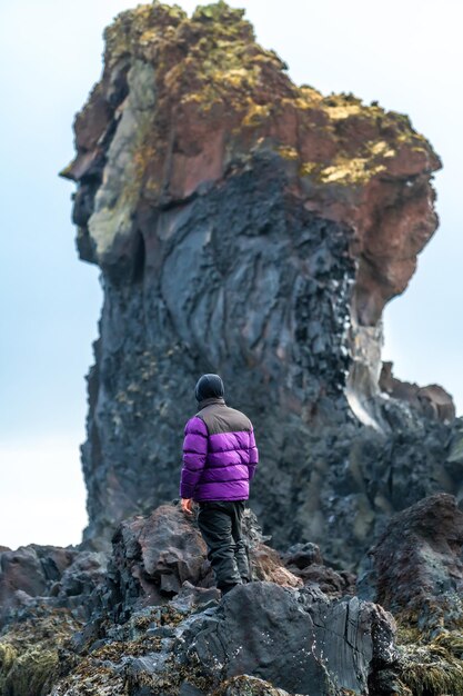 Un jeune homme aventureux sur la plage de Djupalonssandur en hiver en Islande