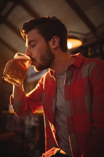 Jeune homme ayant chope de bière