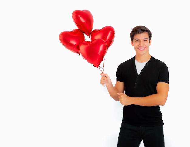 Photo un jeune homme avec un ballon rouge en forme de cœur.