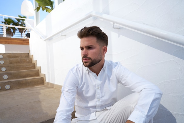 jeune homme barbe dans un starway blanc