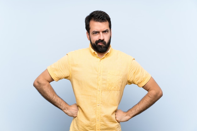 Jeune homme à la barbe isolé bleu en colère