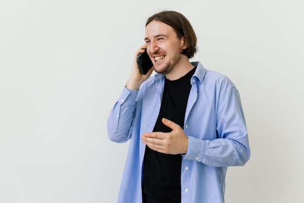 Jeune homme avec barbe marchant et parlant avec un téléphone portable