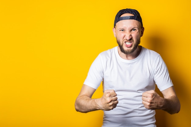 Jeune homme avec une barbe avec les poings fermés montrant la force masculine