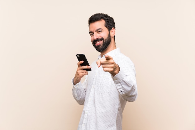 Jeune homme à la barbe tenant un doigt pointant sur vous avec une expression confiante