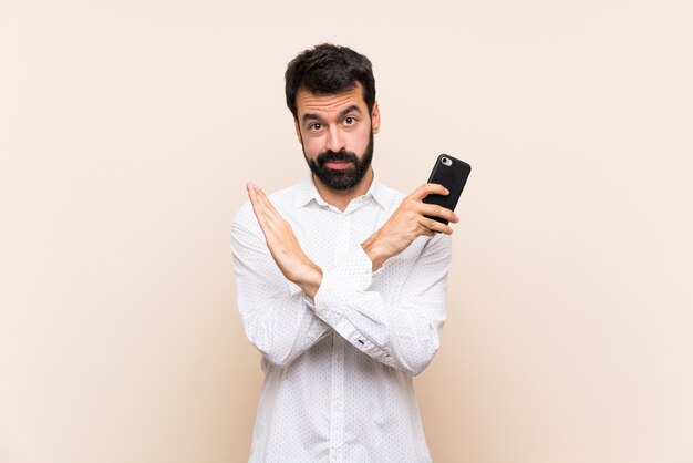 Jeune homme à la barbe tenant un mobile ne faisant aucun geste