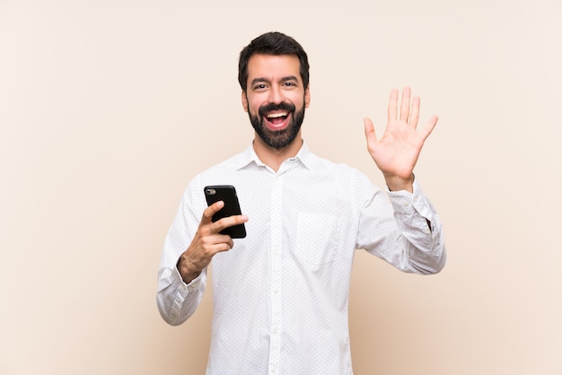 Jeune homme, à, barbe, tenue, mobile, saluer, à, main, à, expression heureuse