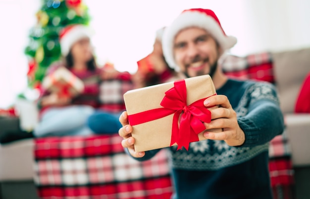 Jeune homme barbu beau heureux dans un bonnet de Noel