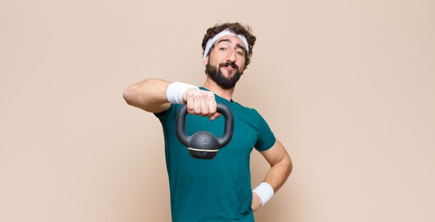 Jeune homme barbu cool au gymnase avec un haltère. concept de sport