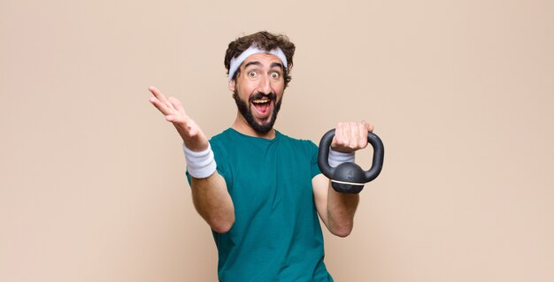 Jeune homme barbu cool au gymnase avec un haltère. concept sportif