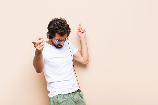 Jeune homme barbu cool écoute de la musique avec un casque