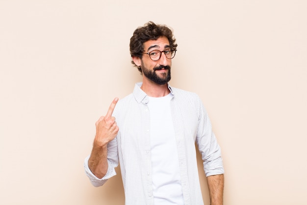 Jeune homme barbu cool avec une expression fière et satisfaite